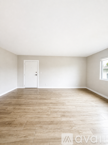 A room with wooden flooring and a white door.
