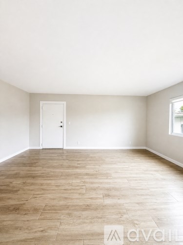A room with wooden flooring and a white door.