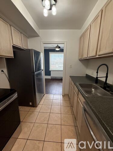 A kitchen with black appliances and beige cabinets.