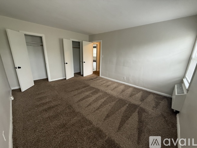 A carpeted room with a brown carpet and white walls.
