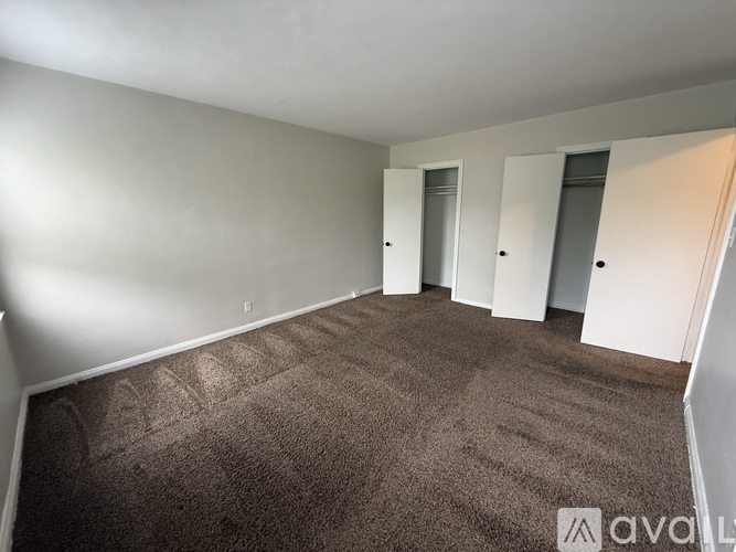 A carpeted room with a brown carpet and white walls.