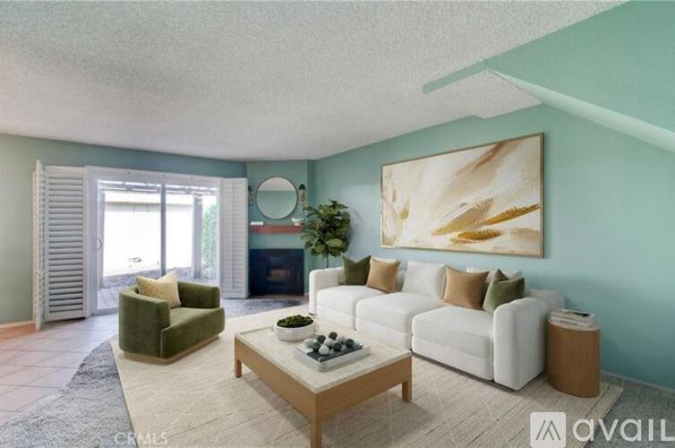 A living room with a white couch, green armchair, and a coffee table.