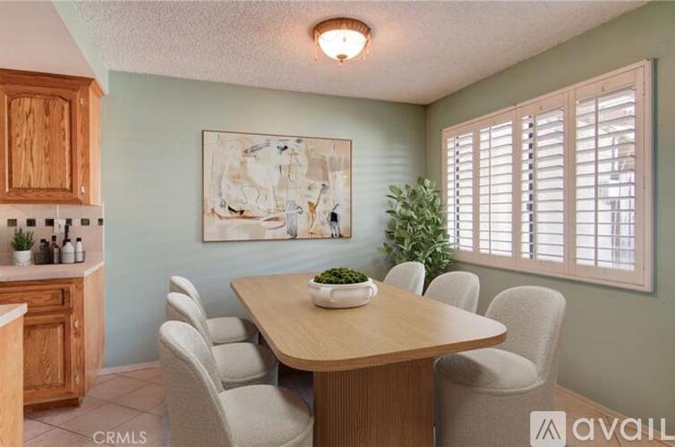 A dining room with a wooden table and chairs.