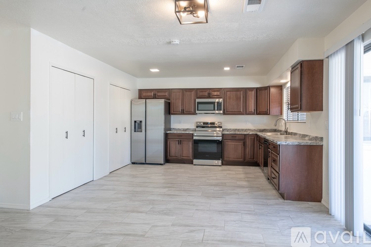 A kitchen with brown cabinets and a white fridge.