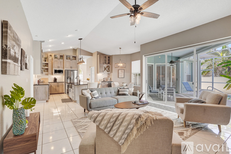 A living room with a grey couch and a ceiling fan.
