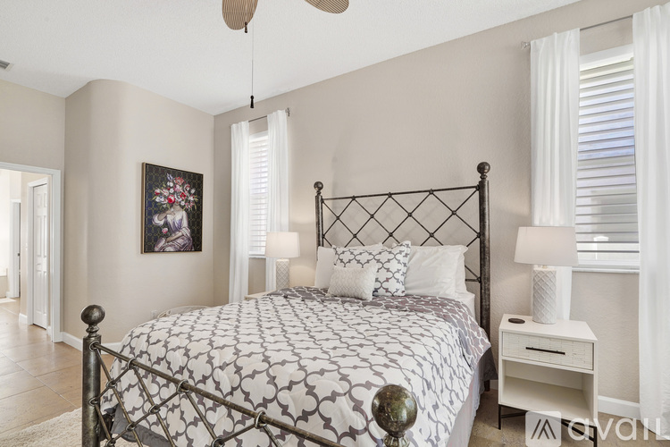 A bedroom with a large bed and a ceiling fan.