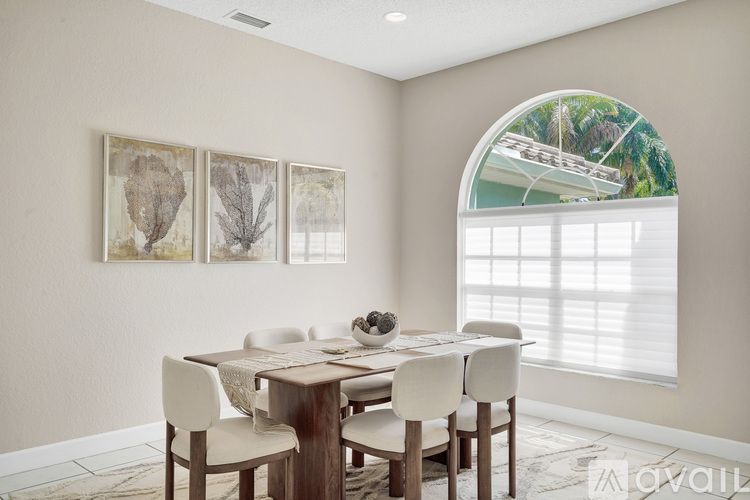 A dining room with a table set for four and a window showing a boat.