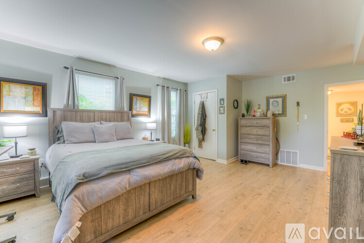 A bedroom with a large bed and wooden floors.