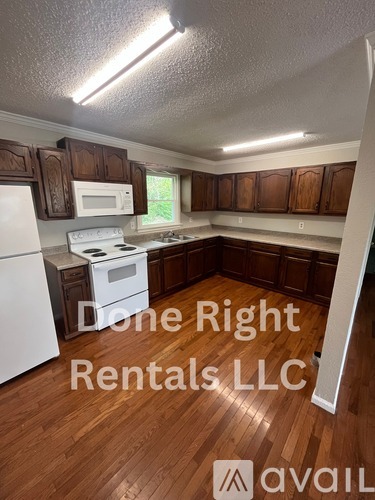 A kitchen with wooden cabinets and a white stove top oven.
