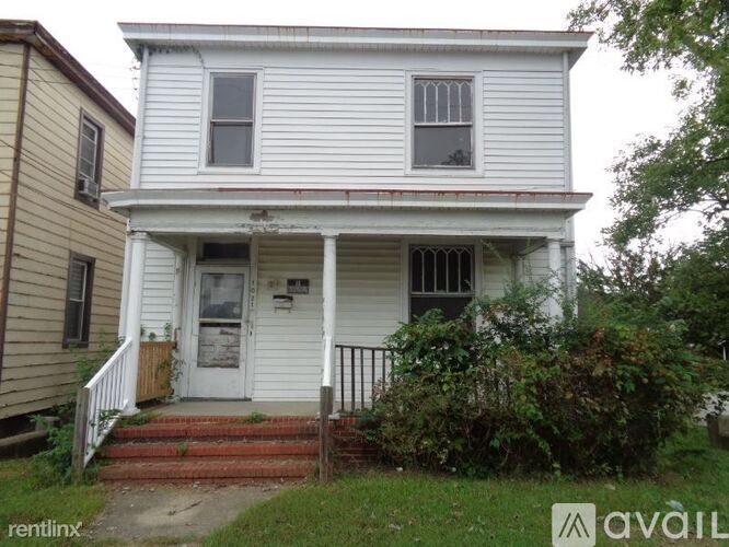 A white house with a porch and a front door.