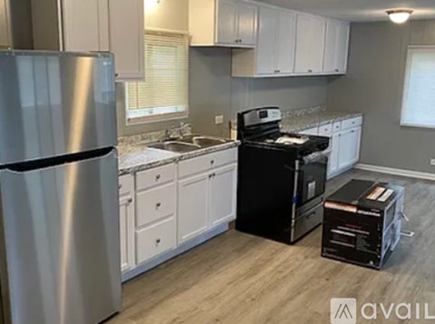 A kitchen with a stainless steel refrigerator and black appliances.