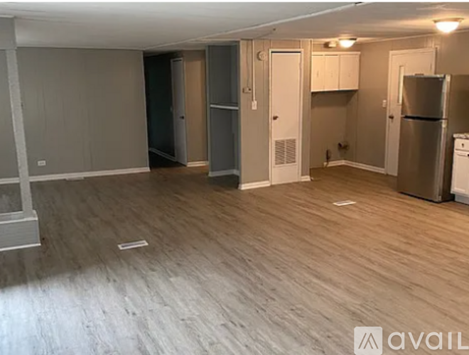 A kitchen area with a refrigerator, oven, and cabinets.