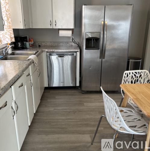 A kitchen with a refrigerator, sink, and dishwasher.