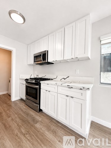 A kitchen with white cabinets and a black stove top.