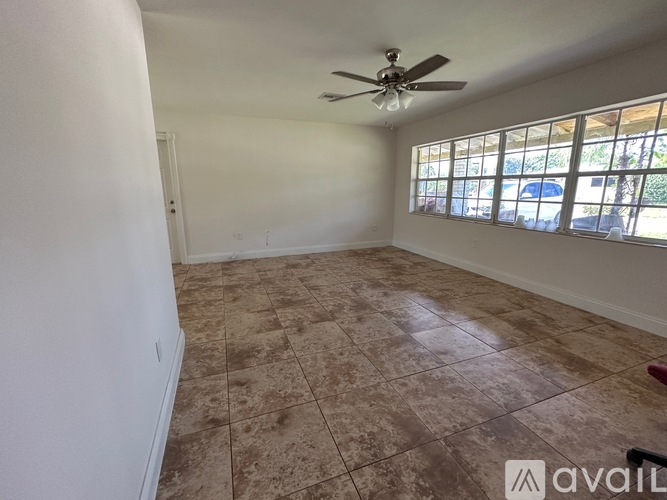A room with a ceiling fan and tiled flooring.