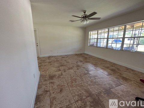 A room with a ceiling fan and tiled flooring.