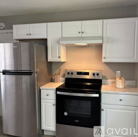 A kitchen with white cabinets and a black stove top oven.