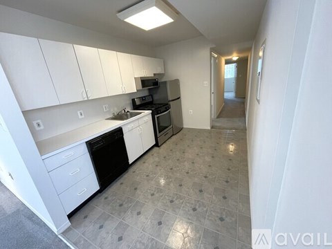 A kitchen with white cabinets and a black dishwasher.