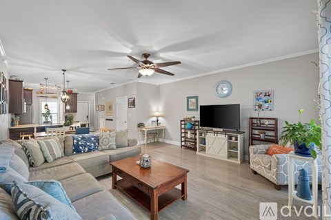 A living room with a sofa set, a coffee table, and a television.