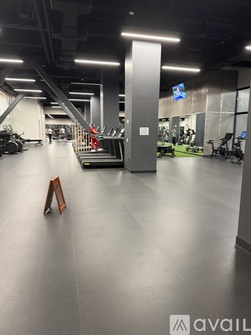 A gym with a variety of equipment including treadmills, weights, and exercise bikes.