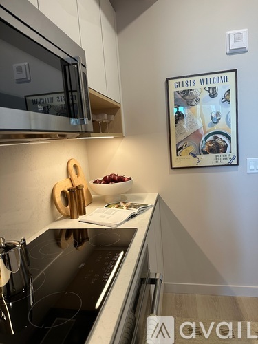 A kitchen with a black counter top and a framed picture on the wall.