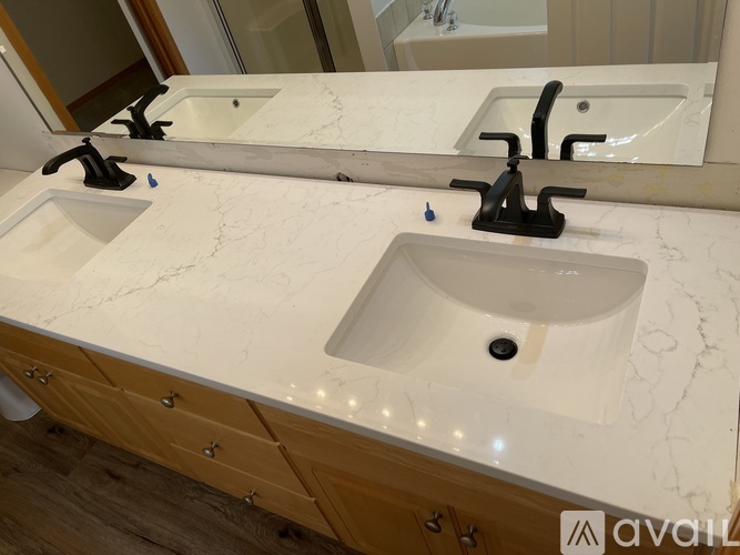 A bathroom with two sinks and a large mirror.