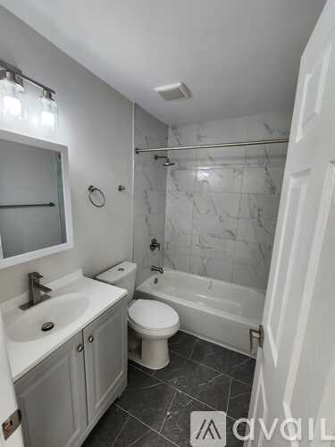 A white bathroom with a toilet, sink, and bathtub.