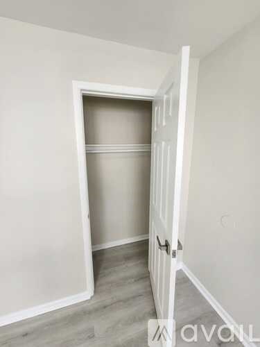 A white door is open to a room with a grey wall.