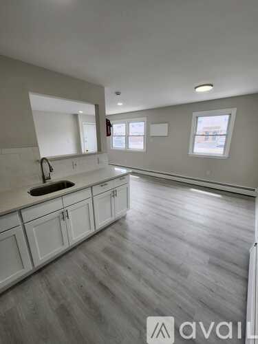 A kitchen with white cabinets and a sink.