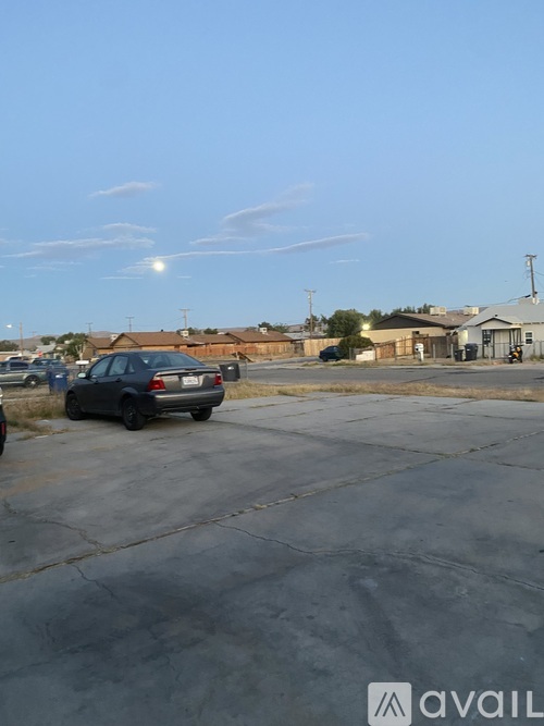 A car is parked in a parking lot with a building in the background.