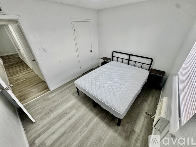 A bedroom with a bed, dresser, and stairs.