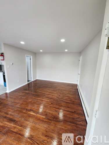 A room with wooden flooring and white walls.