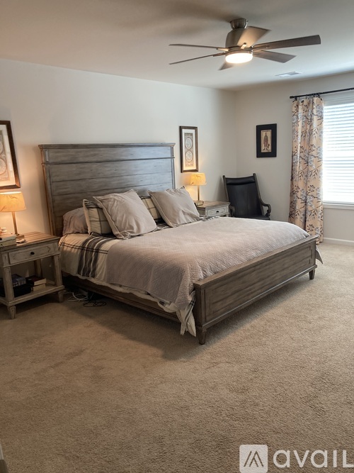 A bedroom with a large bed and a ceiling fan.