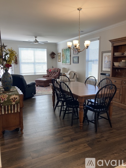 A dining room with a wooden table and chairs.