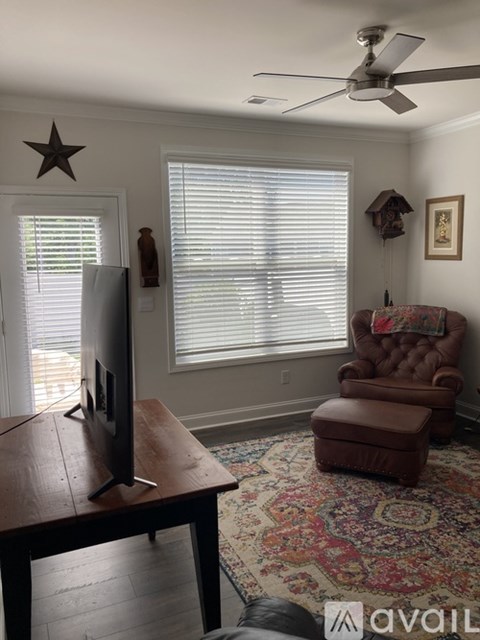 A living room with a brown leather chair and a wooden table.