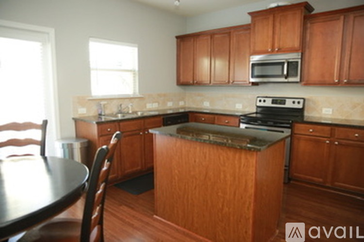 A kitchen with wooden cabinets and a black stove top.