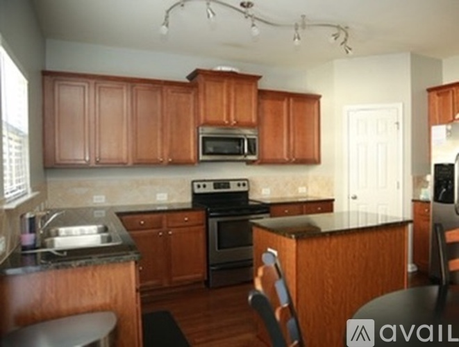 A kitchen with wooden cabinets and a black countertop.