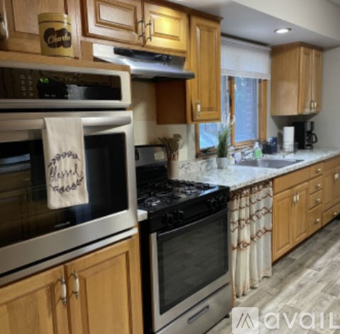 A kitchen with wooden cabinets and a black stove top oven.