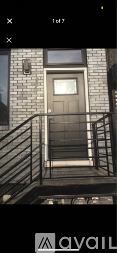 A grey door is on a brick building.