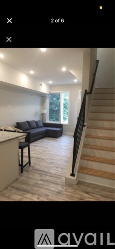 A living room with a couch and a staircase.