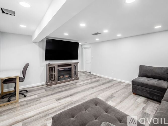 A modern living room with a grey sofa and a television.