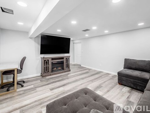 A modern living room with a grey sofa and a television.