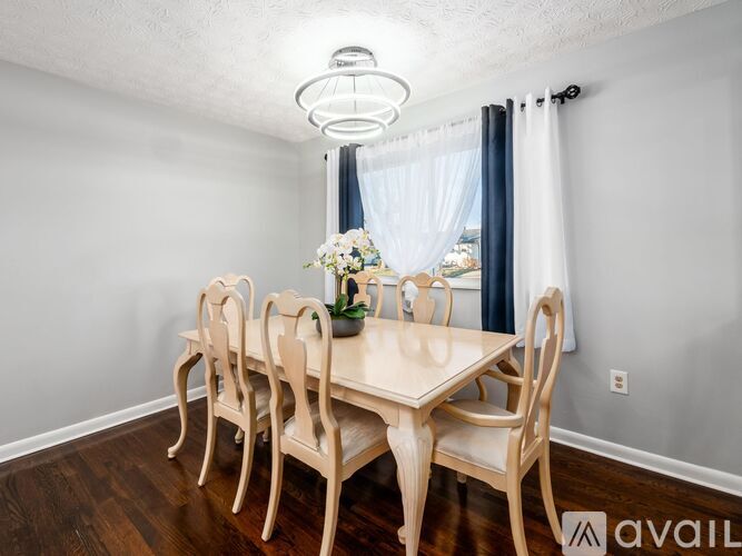 A dining room with a table and chairs.
