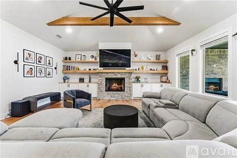 A living room with a grey couch and a fireplace.