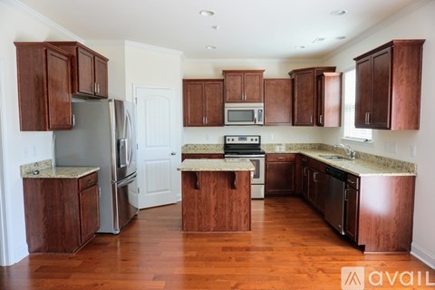 A kitchen with wooden cabinets and a granite countertop.