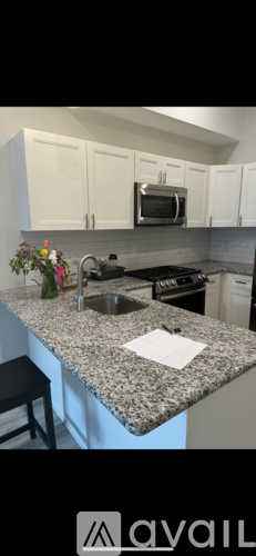 A kitchen with granite countertops and white cabinets.