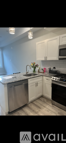 A kitchen with white cabinets and a granite countertop.