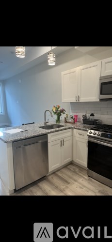 A kitchen with white cabinets and a granite countertop.