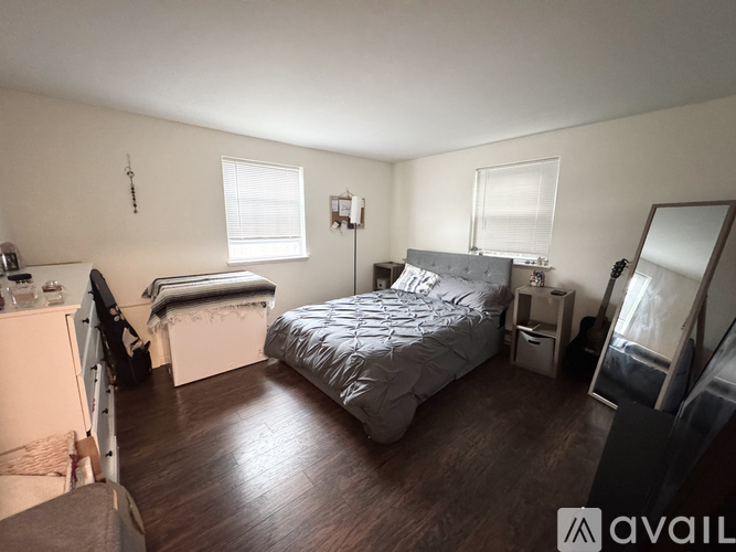 A bedroom with a bed, dresser, and mirror.
