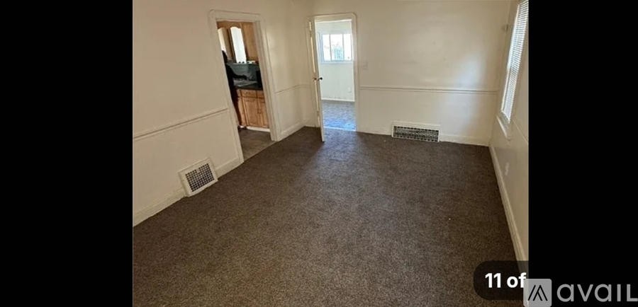A long hallway with a carpeted floor and a door on the right side.